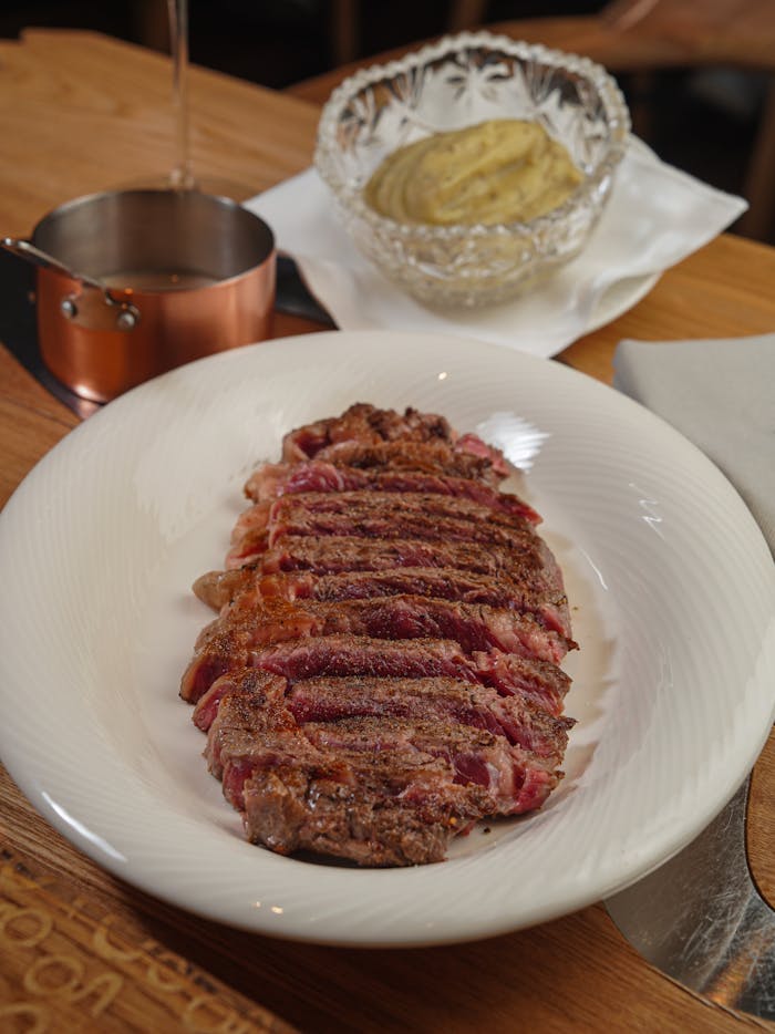 A mouthwatering dish featuring a perfectly seared steak with mashed potatoes and sauce.